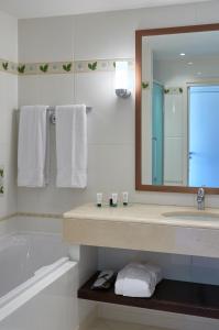 y baño con lavabo, bañera y espejo. en Relais de Margaux - Hôtel & Spa, en Margaux