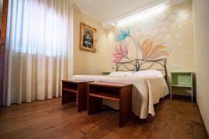 a bedroom with a bed with a desk and a painting on the wall at Villa D'Anzi B&B in Ginosa