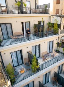 un homme debout sur le balcon d'un bâtiment dans l'établissement PAME Paradiso, à Athènes