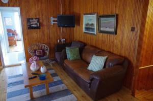 a living room with a brown leather couch and a table at Villa Amy in Mikkeli