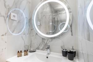 un bagno bianco con lavandino e specchio di Frontière de Monaco - Studio rénové - AE a Beausoleil