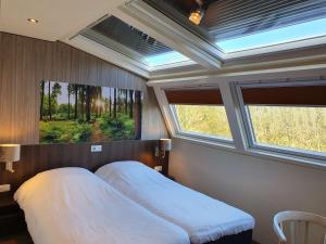 a bedroom with a large bed with two windows at Best Western Hotel Slenaken in Slenaken