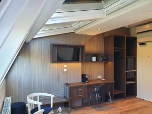 a room with a desk and a tv on a wall at Best Western Hotel Slenaken in Slenaken