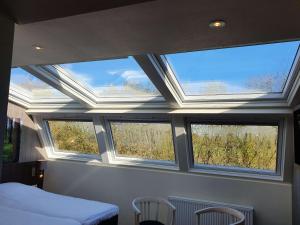 a bedroom with three windows and a bed and chairs at Best Western Hotel Slenaken in Slenaken +52 photos