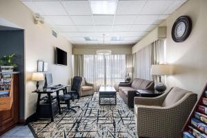 a living room with a couch and a desk at Clarion Inn Cleveland in Cleveland