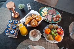 een tafel met borden ontbijtproducten en jus d'orange bij Hôtel Restaurant Port-Conty in Saint Aubin Sauges
