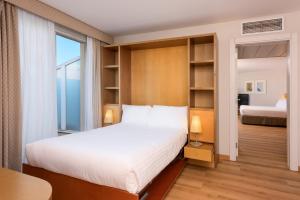 
a bedroom with a large bed and a large window at Hotel Castellon Center Affiliated by Meliá in Castellón de la Plana
