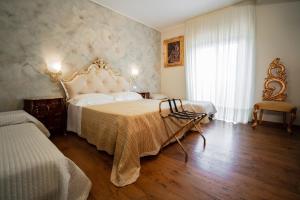 una camera con un grande letto e una finestra di Villa D'Anzi B&B a Ginosa