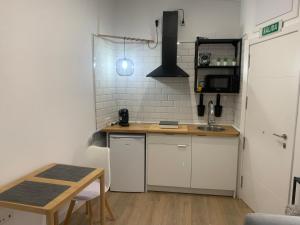 uma pequena cozinha com um lavatório e uma mesa em Puerta de Caceres Apartamento 5 Callejón De Don Álvaro em Cáceres