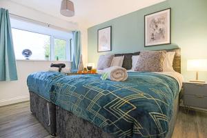 1 dormitorio con 1 cama con manta azul y amarilla en Hornbeam House with Free Parking, Super-Fast WIFI and Smart TV by Yoko Property, en Milton Keynes