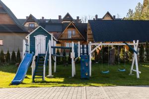 a playground in a yard with a slide at Zakopane Apartamenty 4 Seasons in Zakopane