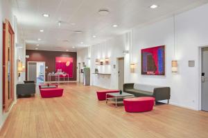 uma sala de estar com um sofá e cadeiras vermelhas em Radisson Blu Hotel i Papirfabrikken, Silkeborg em Silkeborg