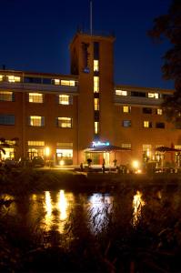 a building at night with a reflection in the water at Radisson Blu Hotel i Papirfabrikken, Silkeborg in Silkeborg