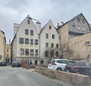 a street with cars parked in front of a building at Apartament Szczęśliwa 13 - Plac Ratuszowy in Jelenia Góra