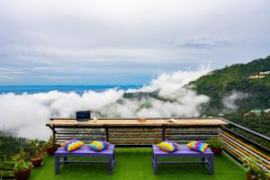 2 bancos púrpuras con almohadas en la cima de una montaña en goSTOPS Mussoorie, Library Road en Mussoorie