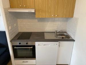 eine kleine Küche mit Spüle und Herd in der Unterkunft T2 pla d'adet au pied des pistes in Saint-Lary-Soulan