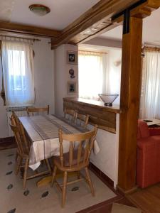 a dining room with a table and chairs and a window at Apartmani Marija in Jahorina