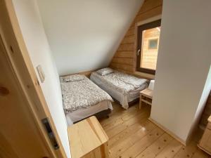 a small room with two beds and a window at DOMKI W CHMURACH in Międzylesie
