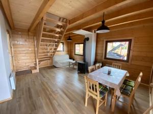 a dining room with a table in a wooden house at DOMKI W CHMURACH in Międzylesie