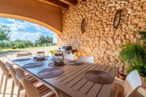 a table and chairs in a room with a stone wall at Son Poca Palla in Sant Llorenç des Cardassar