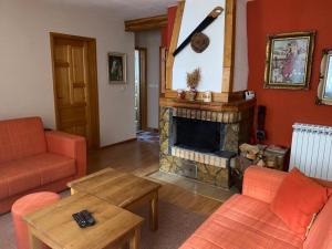 a living room with a fireplace and orange furniture at Apartmani Marija in Jahorina