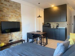 a bedroom with a bed and a table and a kitchen at Milmari Lux N8 in Kopaonik