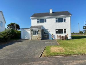 a large white house with a large driveway at Deu Draeth in Abersoch