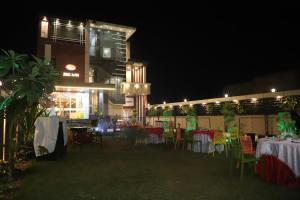 a restaurant with tables and chairs at night at SRG INN HOTEL in Bharatpur