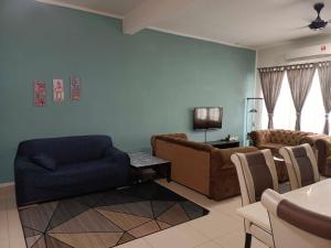 een woonkamer met een bank en een stoel bij Homestay DTepian Bayu Bandar Seri Impian Kluang in Kluang