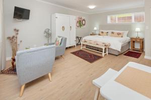 een slaapkamer met een bed, een bank en een tafel bij 6 Stemmet Lodge in Hermanus