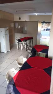 a room with two tables and chairs and a kitchen at Hotel Brasil in Presidente Prudente