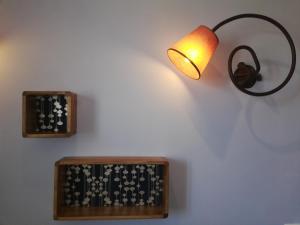 uma lâmpada numa parede ao lado de um relógio na parede em Le Régence em Arles