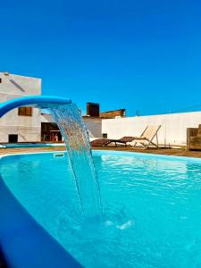 a water fountain in a swimming pool at Hotel Villa de Carli in Bagé