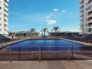 a large swimming pool with palm trees and buildings at Patacona Green Holiday in Valencia