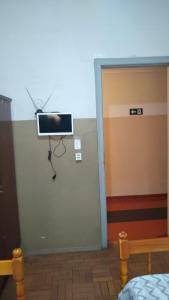 a room with a door with a tv on the wall at Hotel Brasil in Presidente Prudente