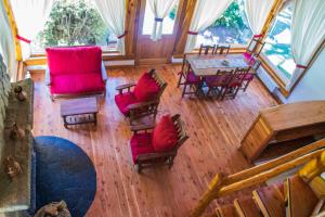 vistas panorámicas a una sala de estar con mesa y sillas en Cabañas Ruca Kuyen Golf & Resort en Villa La Angostura