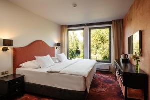 a bedroom with a bed and a large window at HERBARIUM boutique hotel in Olomouc
