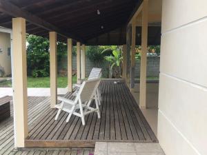 twee stoelen op een terras met een huis bij Casa grande na Gamboa Garopaba in Garopaba