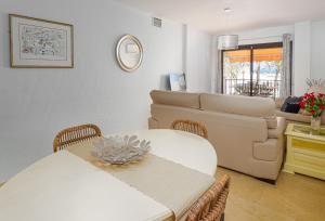 uma sala de estar com uma mesa e um sofá em Frontline Beach Apartment Marina Real 5009 em Manilva