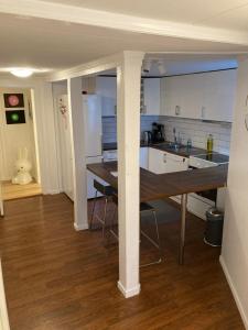 una cocina con una mesa larga en una habitación en Kjellerleilighet - nært Haukeland sykehus., en Bergen