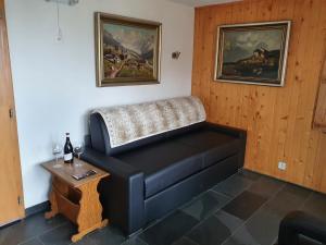 um sofá num quarto com uma mesa e pinturas em Premium Jacuzzi Central Verbier Studio, High Floor em Verbier
