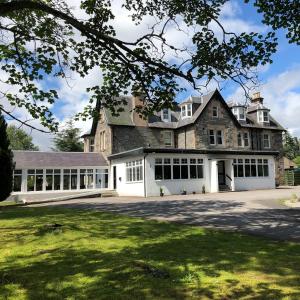 a large stone house with a large driveway at The Speyside Hotel and Restaurant in Grantown on Spey