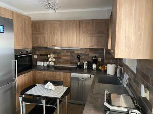a kitchen with wooden cabinets and a table in it at Comfortable & quiet apartment 1 in Alexandroupoli
