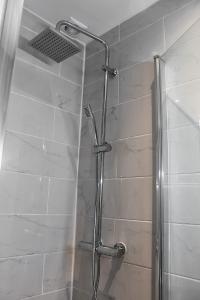 ducha con puerta de cristal y cabezal de ducha en Le 8 ∙ Appartement cosy avec balcon vue sur mer, en Mers-les-Bains