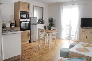 una cocina con mesa y sillas y una cocina con mesa en Le 8 ∙ Appartement cosy avec balcon vue sur mer, en Mers-les-Bains