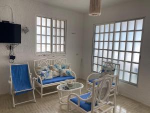 a living room with chairs and a couch and windows at Villa Gaviotas el cuyo beach in El Cuyo