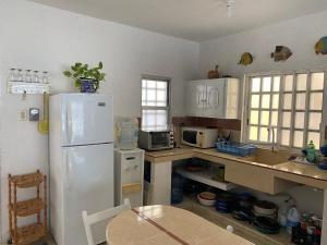 a kitchen with a white refrigerator and a table at Villa Gaviotas el cuyo beach in El Cuyo