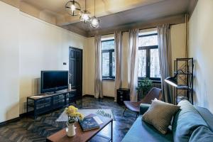 a living room with a couch and a tv at Sweet Dreams Suites Piata Romana in Bucharest
