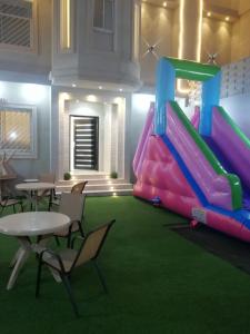 a play room with a slide and tables and chairs at شاليهات اليخت بالبشائر in Al Qārah