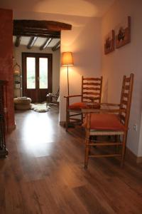 a living room with two chairs and a table at Casa Rural Urbe in Campodarbe